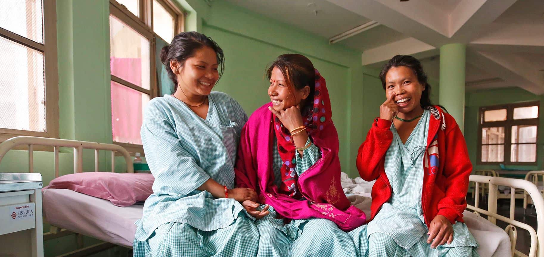 Nepalese women in ward, sitting on edge of bed