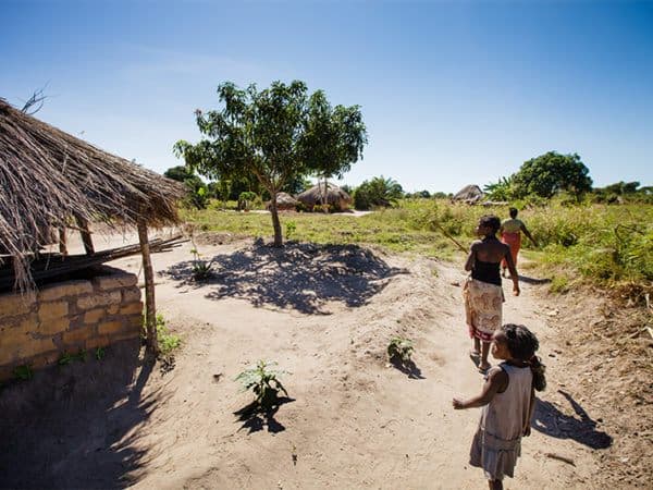 Three women walk through a remote village in Zambia